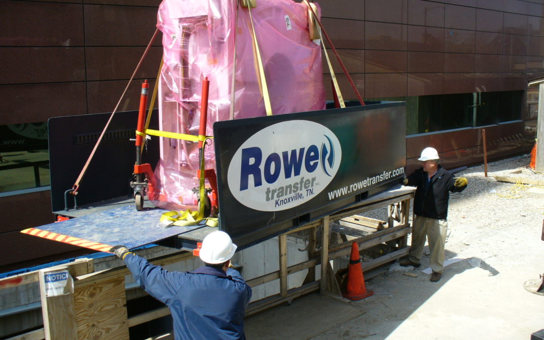 Two Rowe Transfer employees helping guide a rigging project